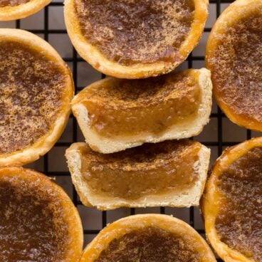 close up image of butter tart cut in half on cooling rack