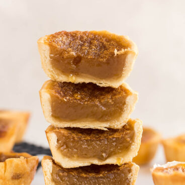 stack of four butter tarts cut in half to reveal filling