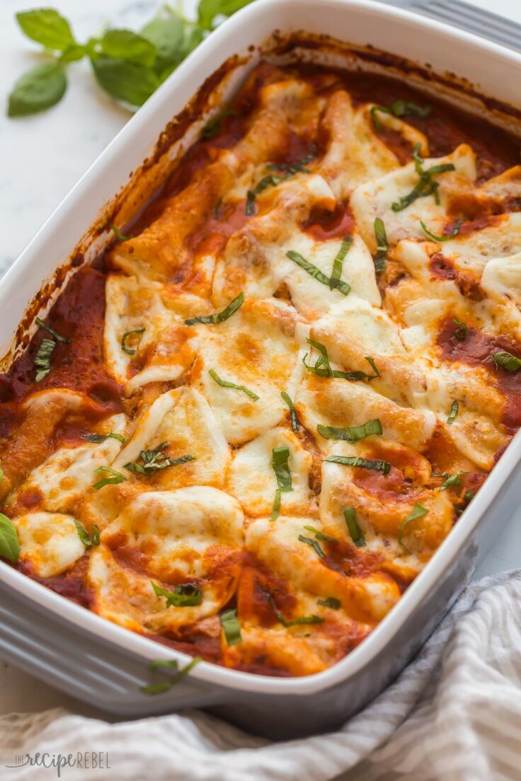 close up image of cheese cannelloni with fresh basil on top
