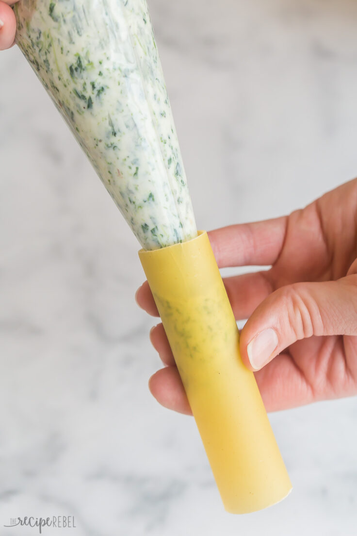 piping bag with ricotta filling going into oven ready cannelloni noodle