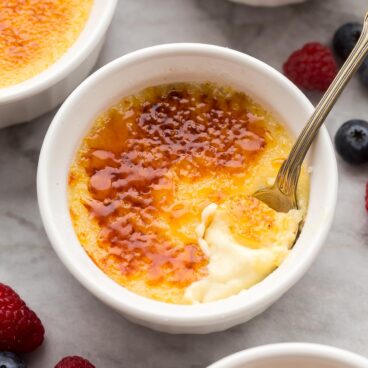 close up view of spoon scooping creme brulee