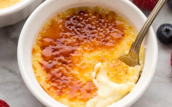 close up view of spoon scooping creme brulee