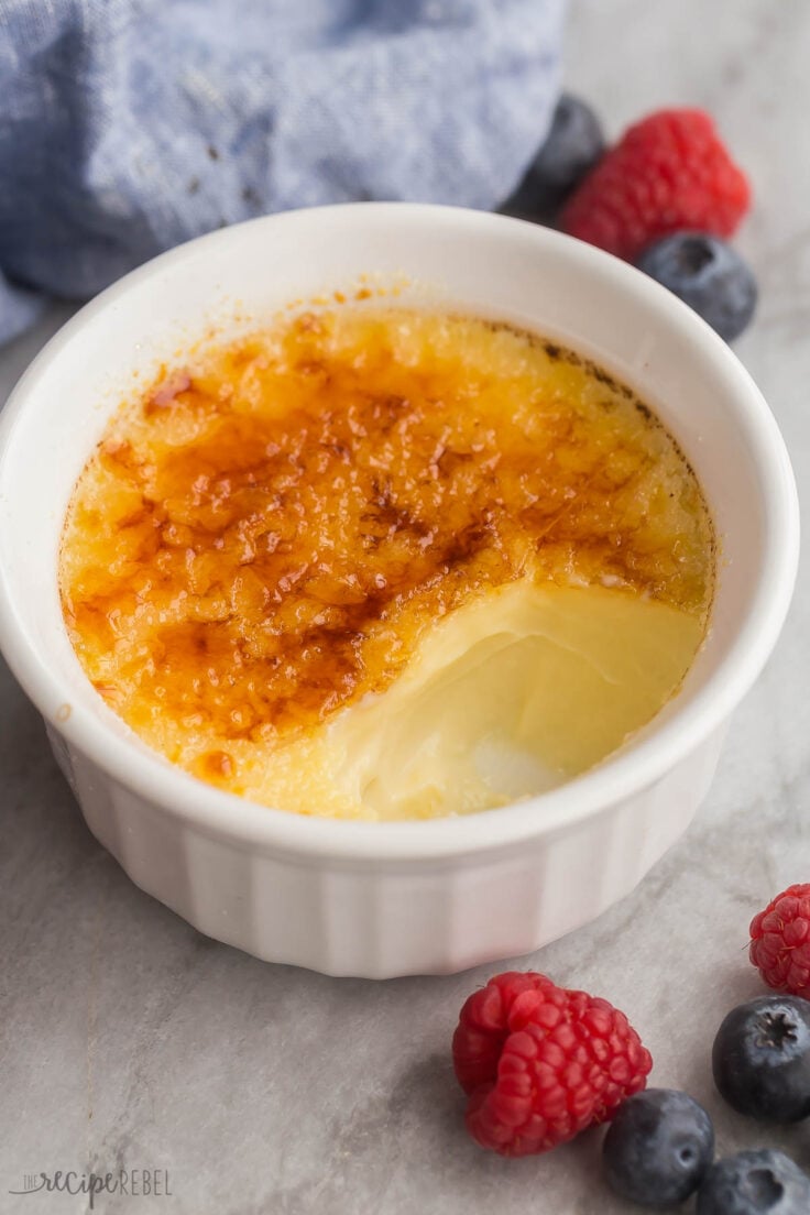 close up view of creme brulee in ramekin with several bites missing