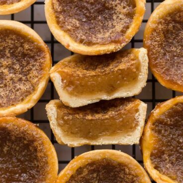 close up image of butter tart cut in half on cooling rack