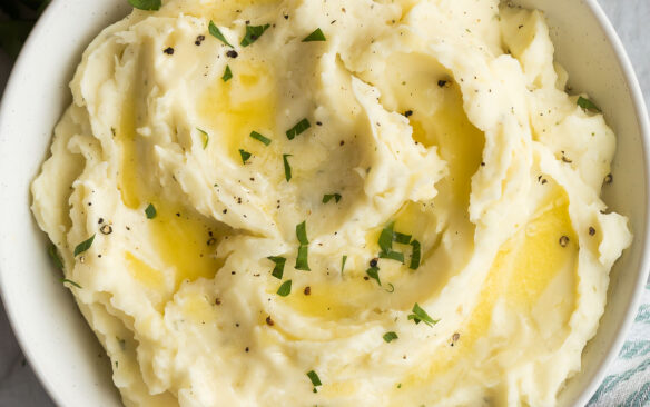 square overhead image of garlic mashed potatoes with melted butter