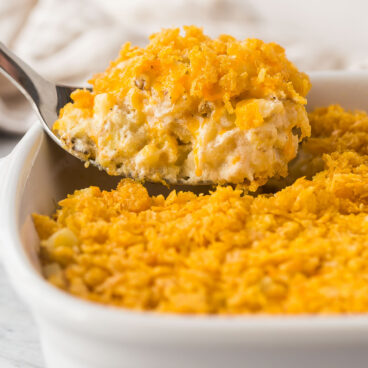 close up image of metal spoon scooping hashbrown casserole