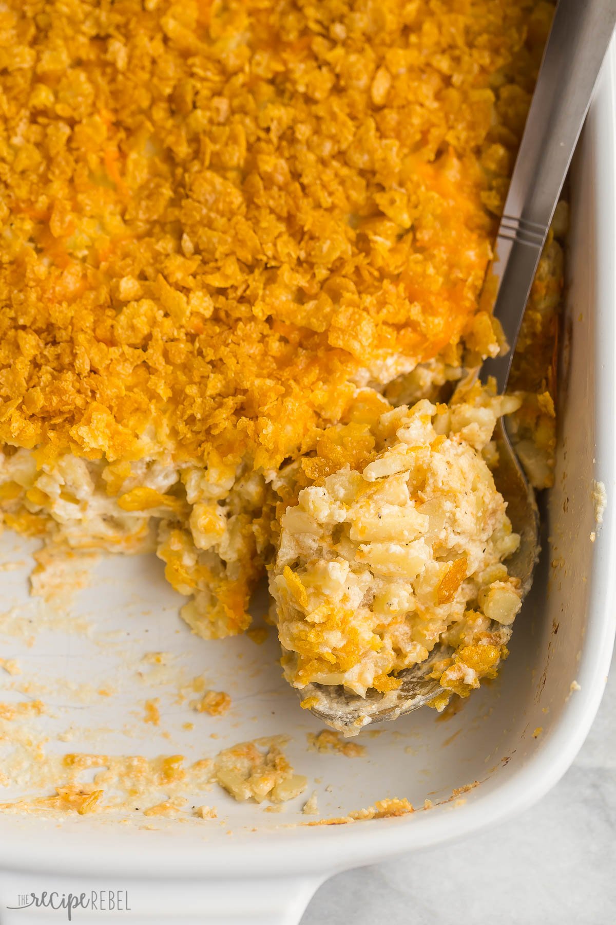 overhead image of metal scoop in pan of hashbrown casserole