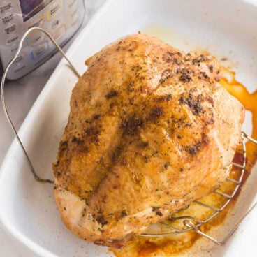 instant pot turkey breast in baking dish in front of pressure cooker