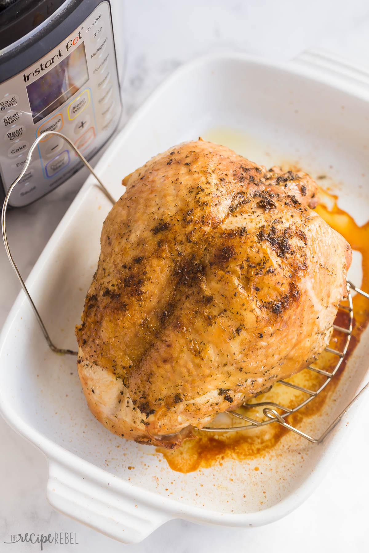 instant pot turkey breast in baking dish in front of pressure cooker