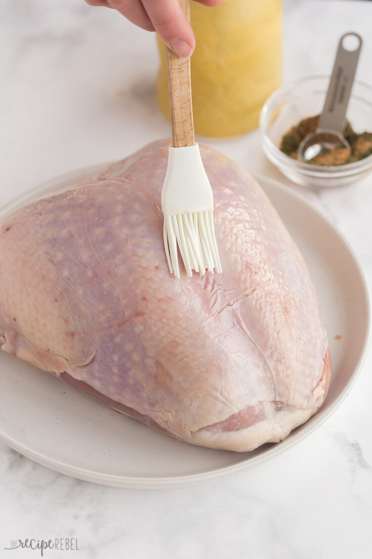 bone in turkey breast being brushed with oil