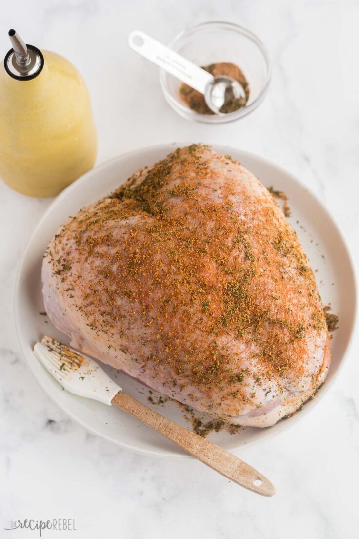 uncooked turkey breast with seasoning on top
