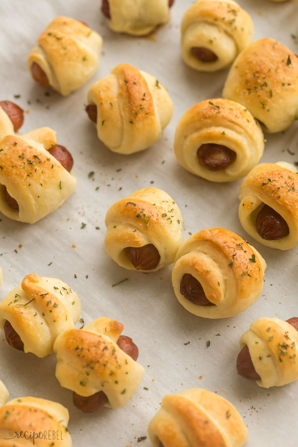 finished pigs in a blanket on parchment paper on a baking sheet