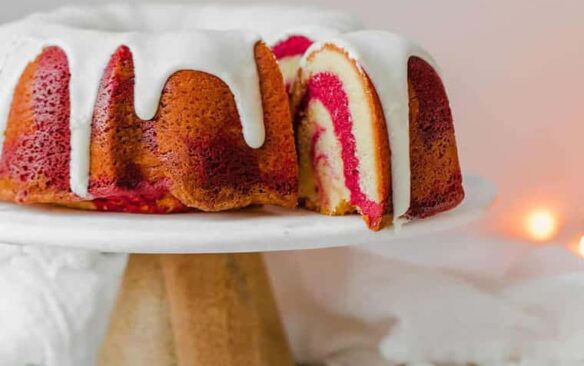 red velvet marble cake on cake stand with white frosting