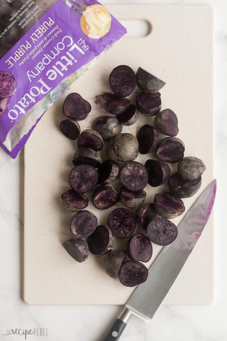 purple potatoes halved on a cutting board