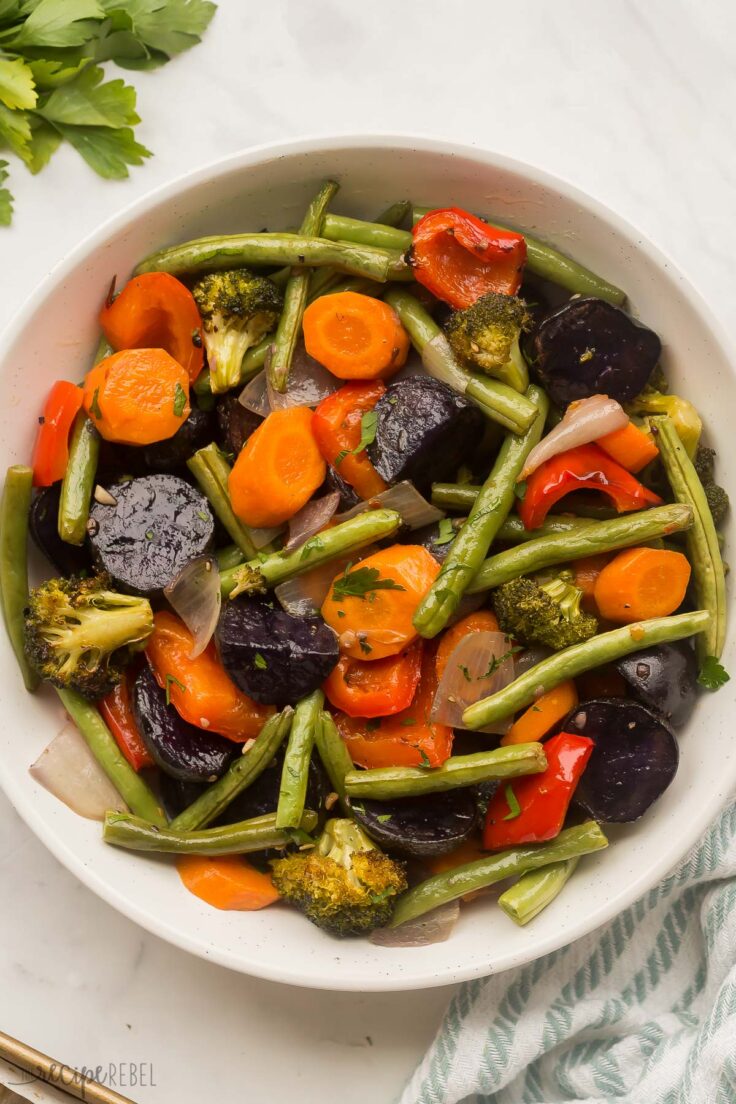 These Roasted Vegetables are made up of a colorful blend of veggies that are perfectly seasoned with fresh garlic, butter, cracked pepper, and parsley! This 5-minute side dish pairs perfectly with any meal! #vegetables #recipe | side dish recipes | healthy recipes | healthy dinner | vegetarian | easy dinner ideas big bowl of roasted vegetables
