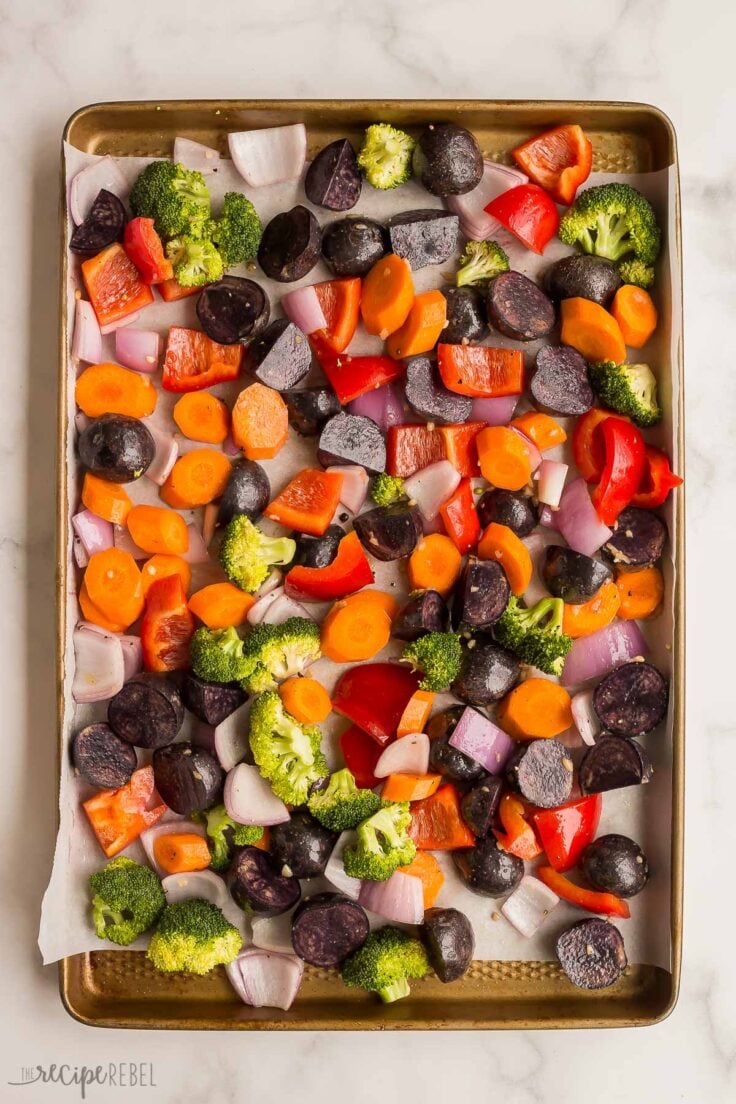 overhead image of uncooked vegetables on a sheet pan
