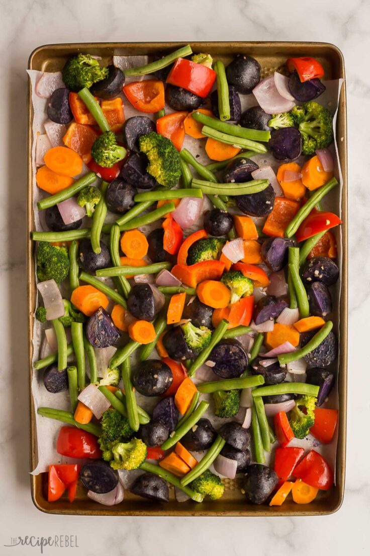 overhead image of vegetables before roasting with green beans added