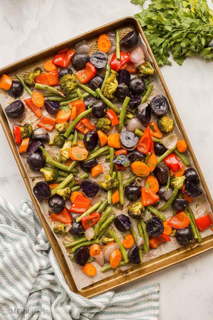 These Roasted Vegetables are made up of a colorful blend of veggies that are perfectly seasoned with fresh garlic, butter, cracked pepper, and parsley! This 5-minute side dish pairs perfectly with any meal! #vegetables #recipe | side dish recipes | healthy recipes | healthy dinner | vegetarian | easy dinner ideas overhead image of roasted vegetables on sheet pan