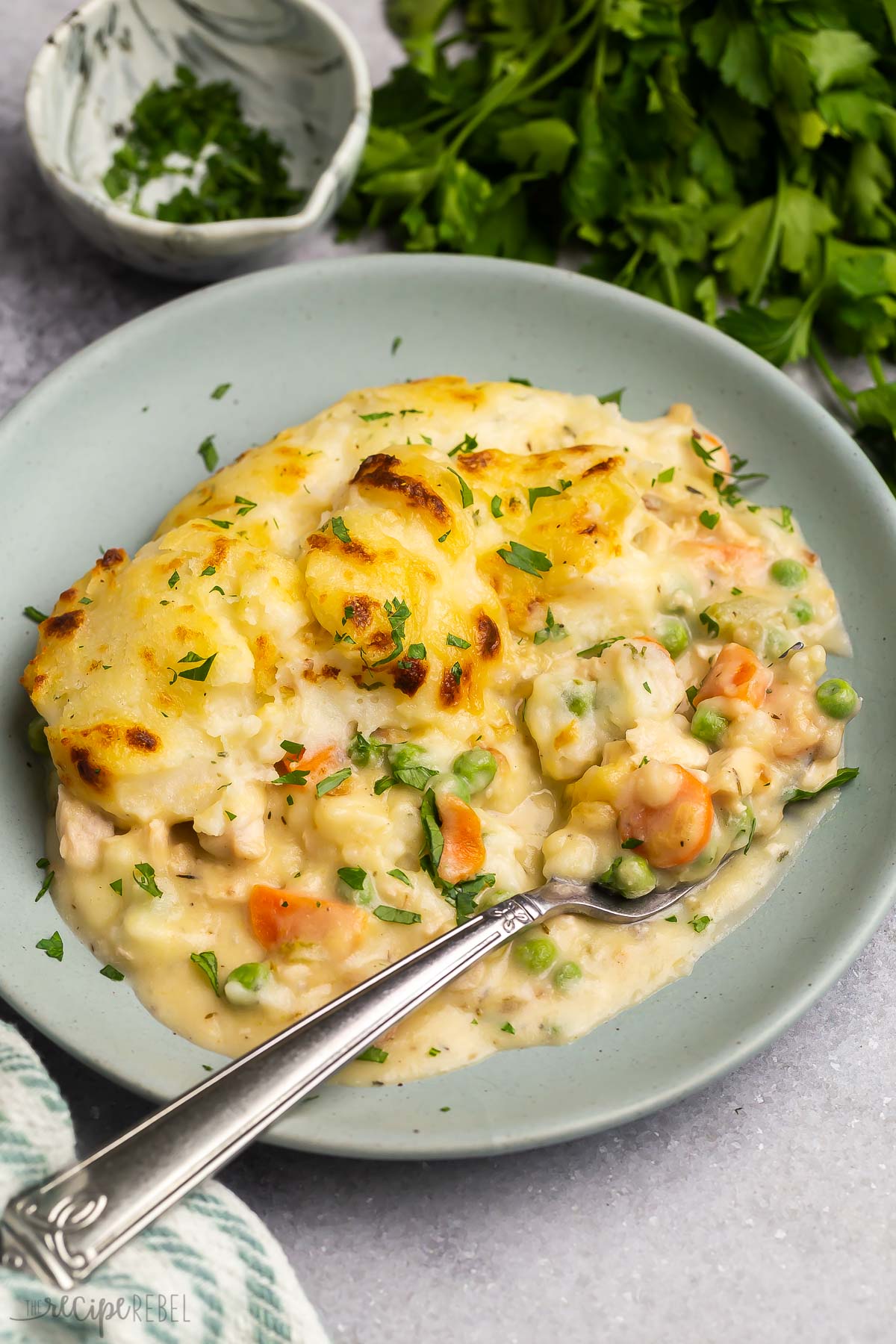 turkey shepherd's pie on grey plate with fork stuck in.