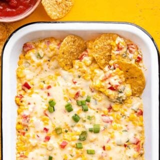 Overhead view of hot corn dip with a few tortilla chips