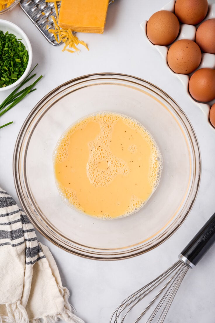 omelette ingredients whisked together in glass bowl