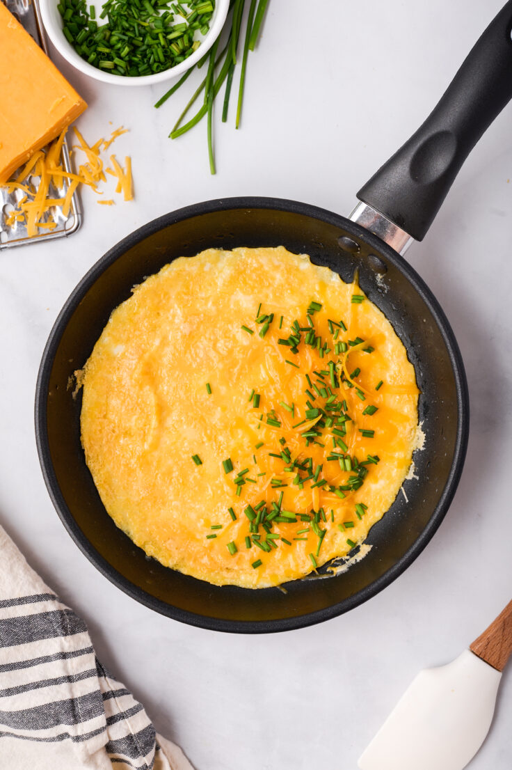 omelette with cheese and chives added to one half