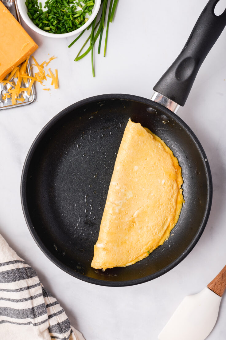 omelette folded in half in black skillet