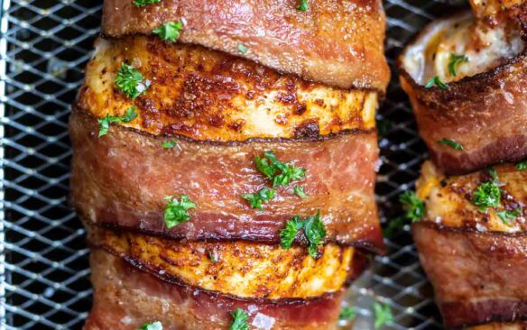 Air fryer chicken wrapped in bacon on a plate.