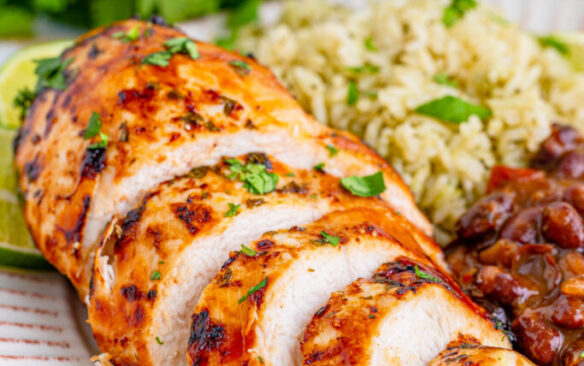 Margarita chicken breast sliced and served with Mexican rice and black beans.