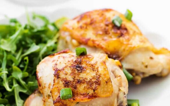 Air fryer Ranch chicken next to greens on a plate.