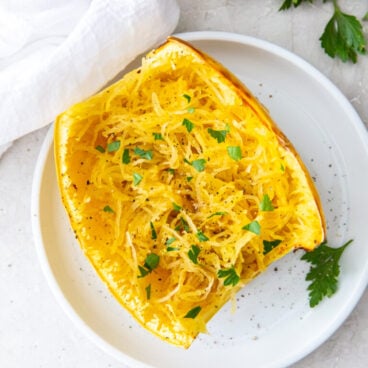 air fryer spaghetti squash cut in half on white plate