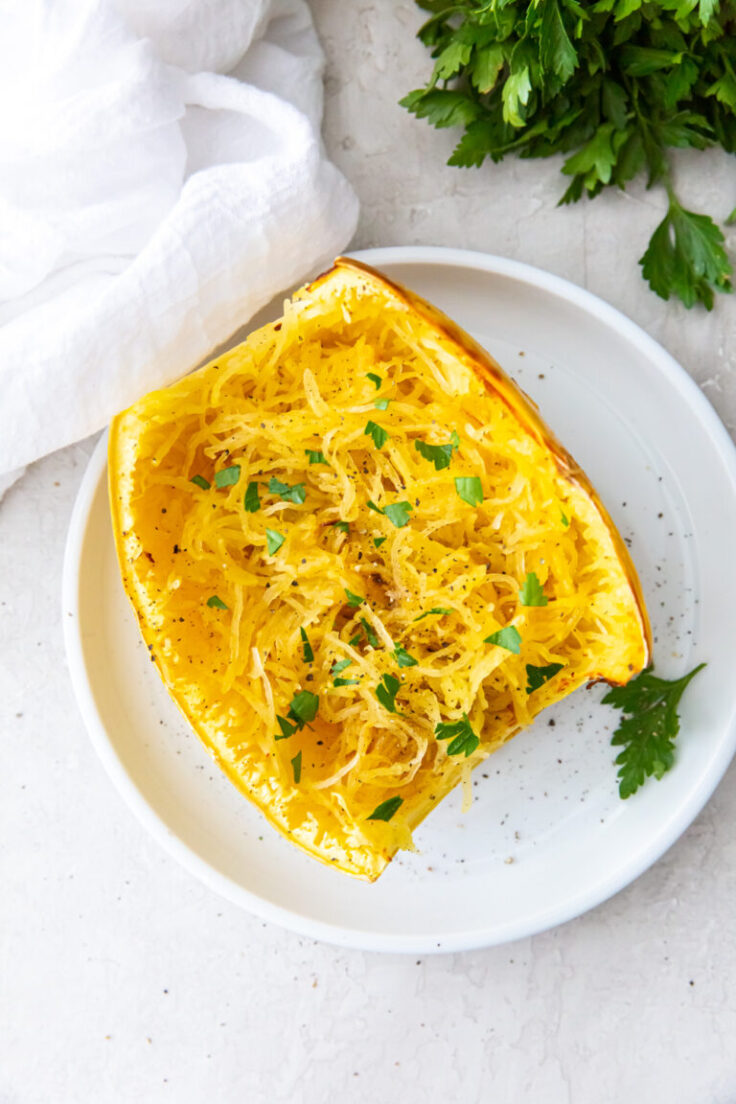 air fryer spaghetti squash cut in half on white plate