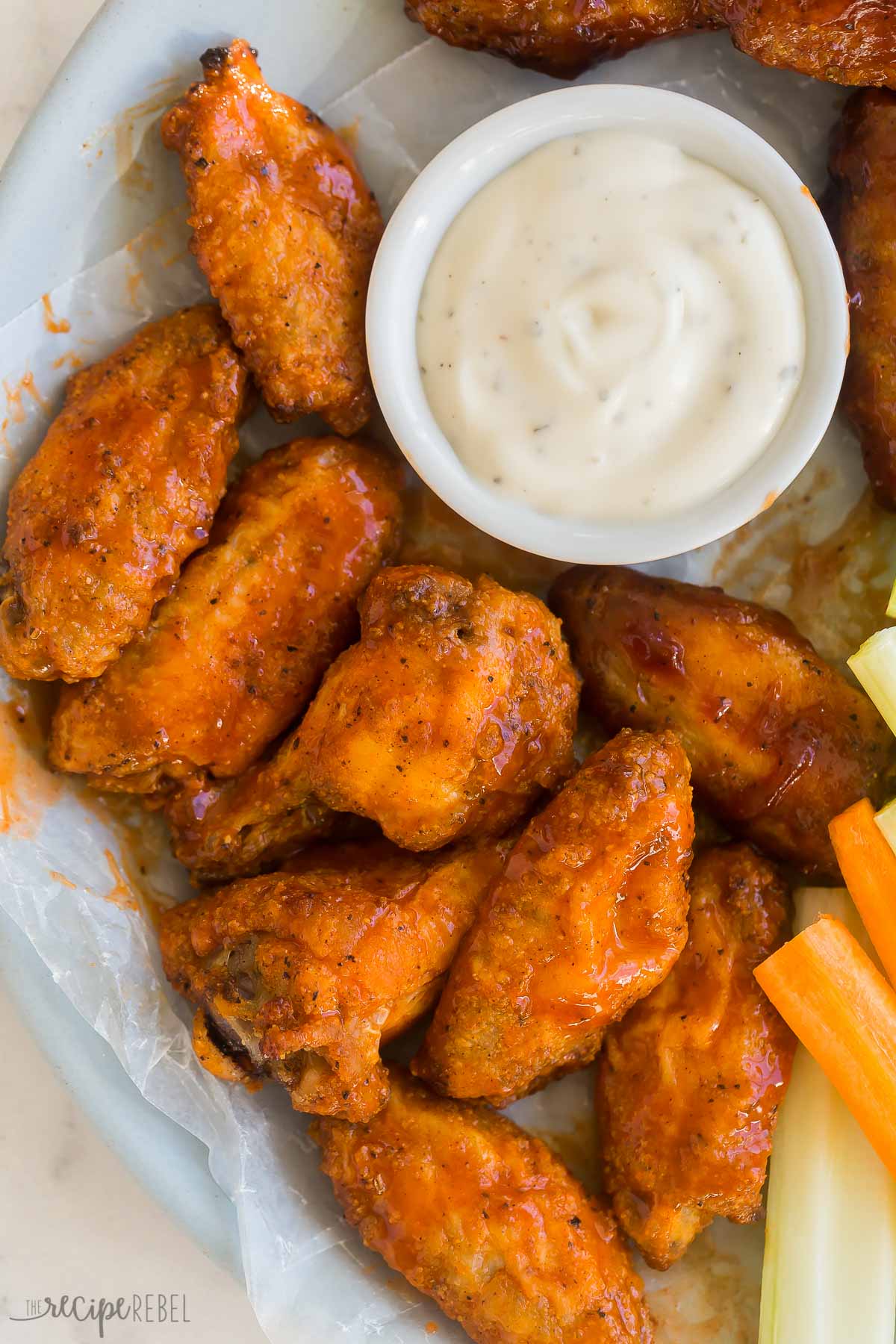 close up image of baked chicken wings coated in buffalo sauce
