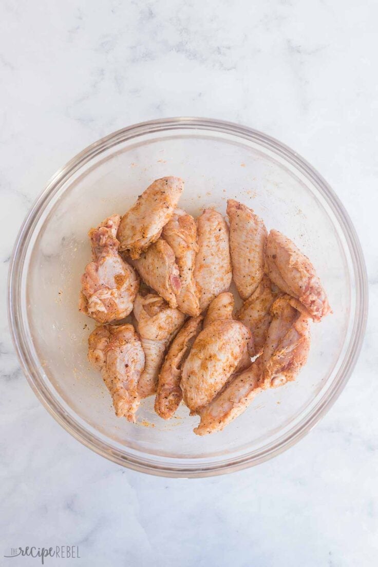 seasoned chicken wings in glass bowl