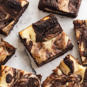 several pieces of cream cheese brownies on a white background