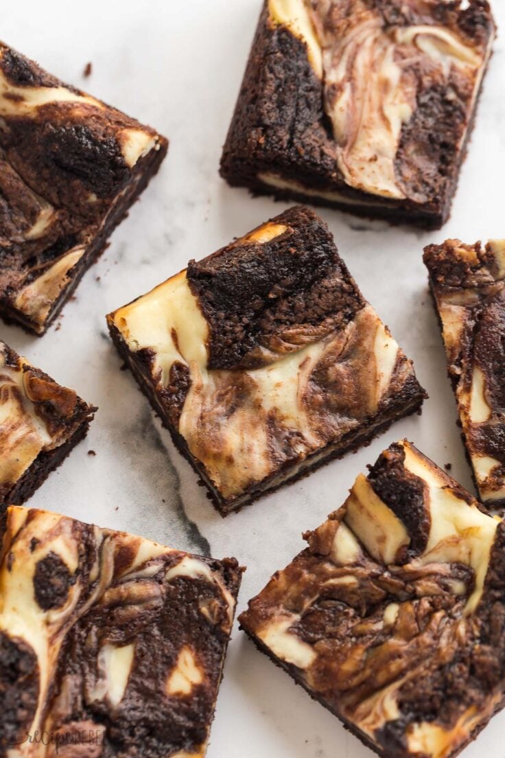several pieces of cream cheese brownies on a white background