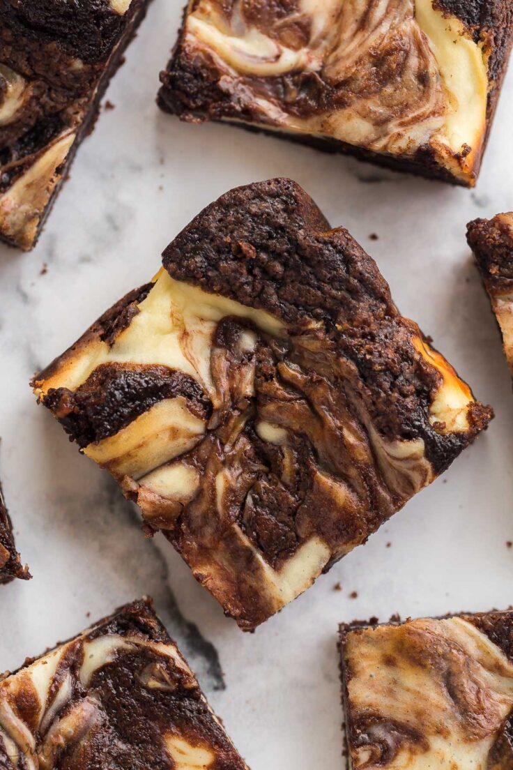 close up image of one cream cheese brownie on a white background