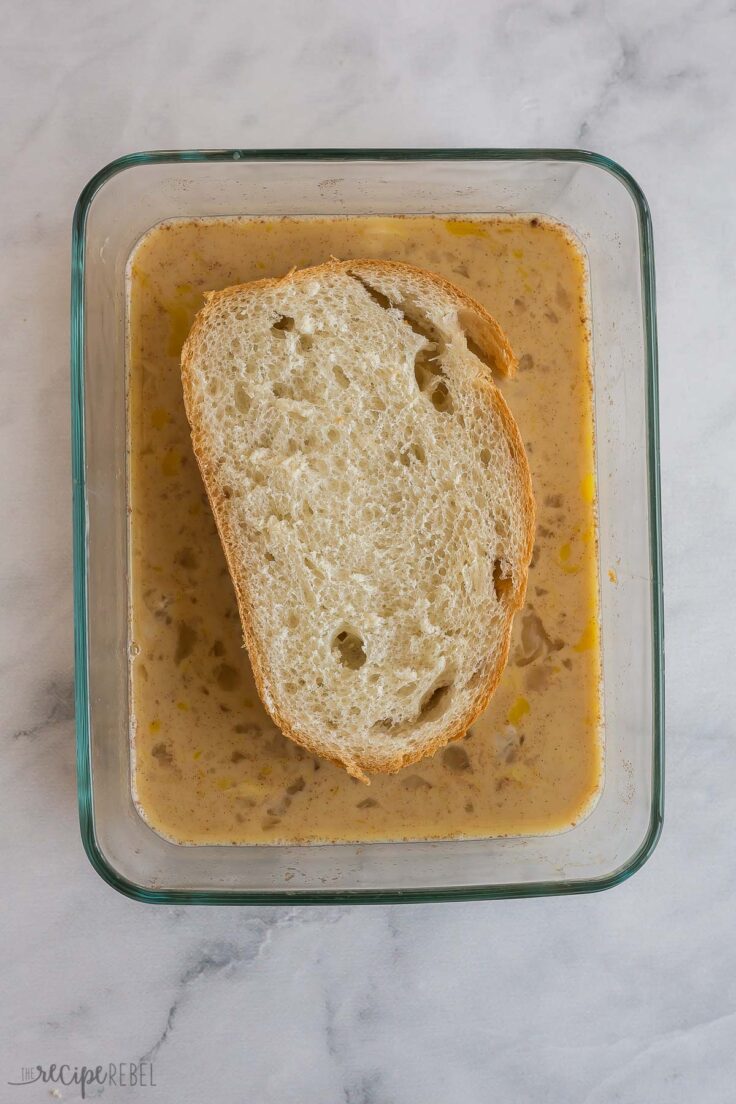 french bread slice being dunked in egg mixture