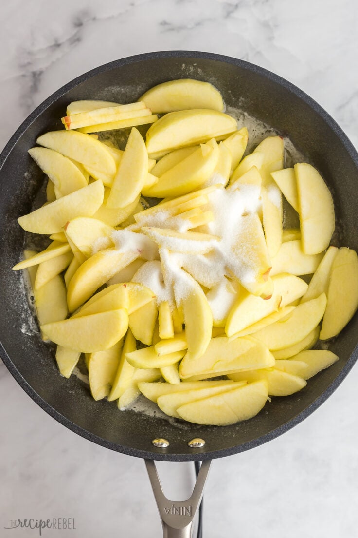 granulated sugar added to apple slices in frying pan