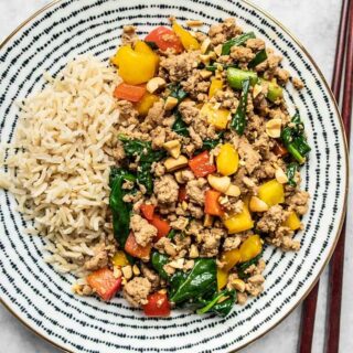 Ground turkey stir fry on a plate with a side of rice.