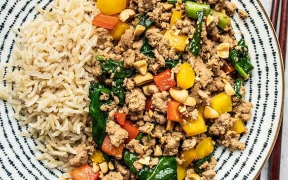 Ground turkey stir fry on a plate with a side of rice.