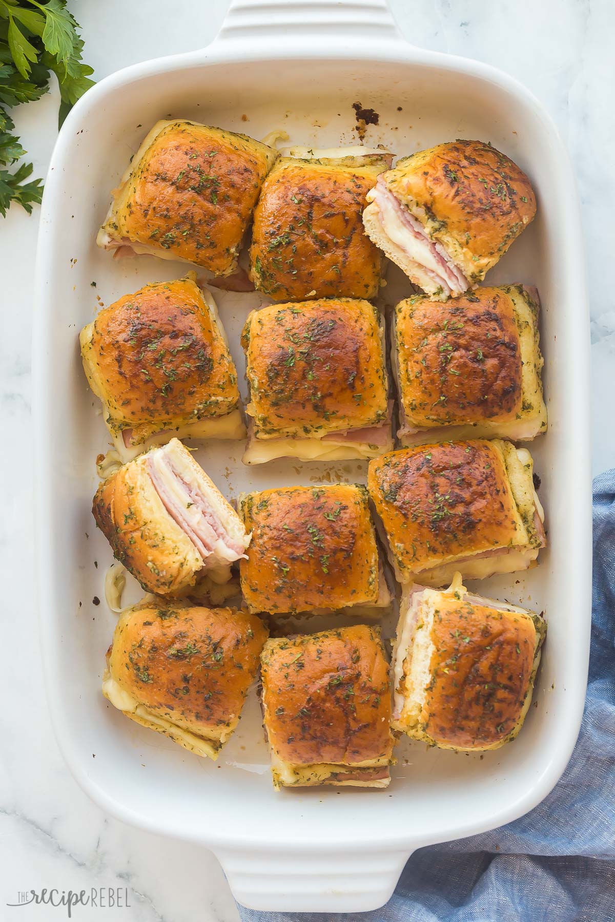 overhead image of ham and cheese sliders cut apart in baking dish