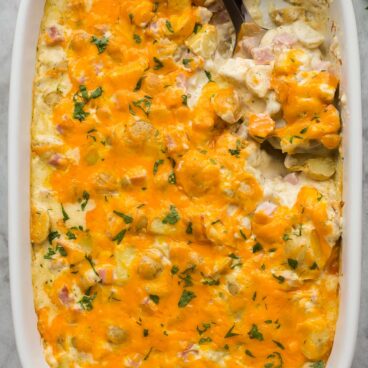 overhead image of pan of ham and potato casserole with spoon stuck in