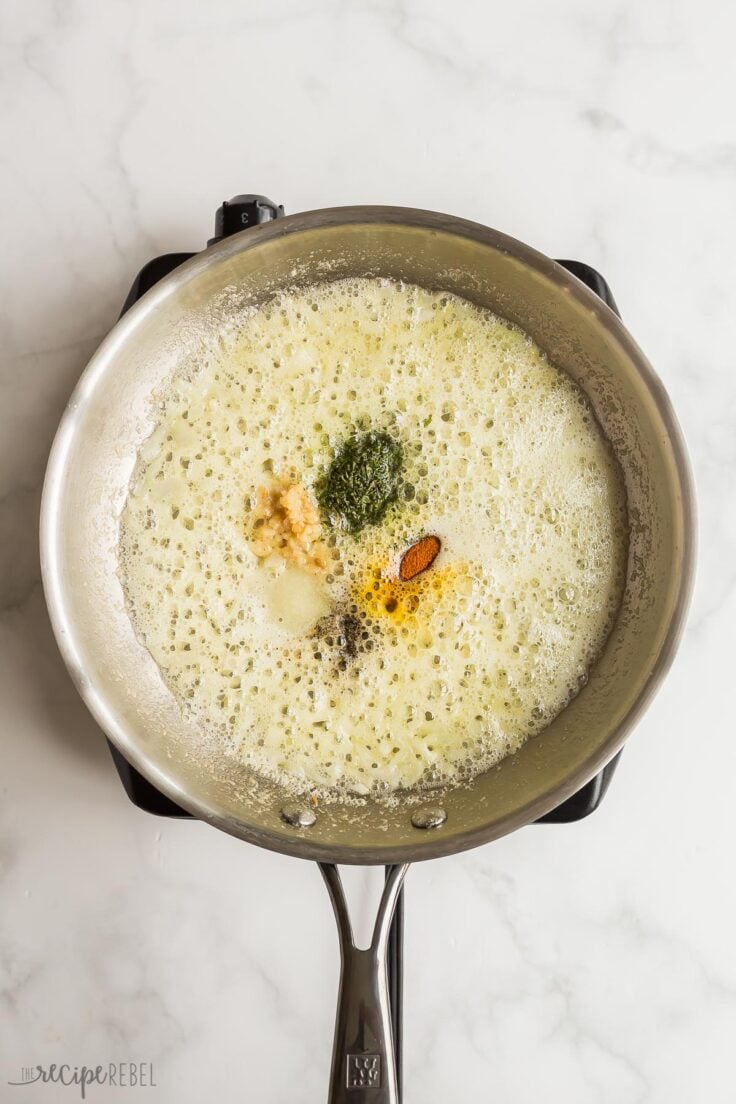 spices added to butter and onion in pan