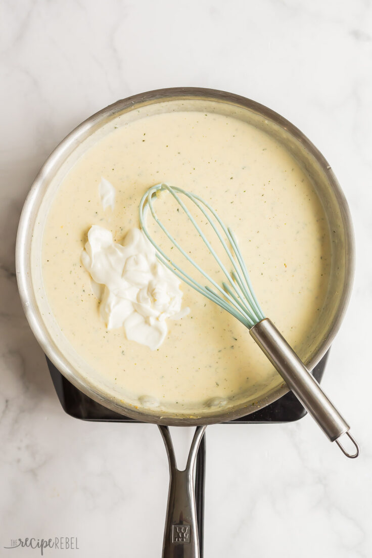 sour cream being stirred into sauce in pan