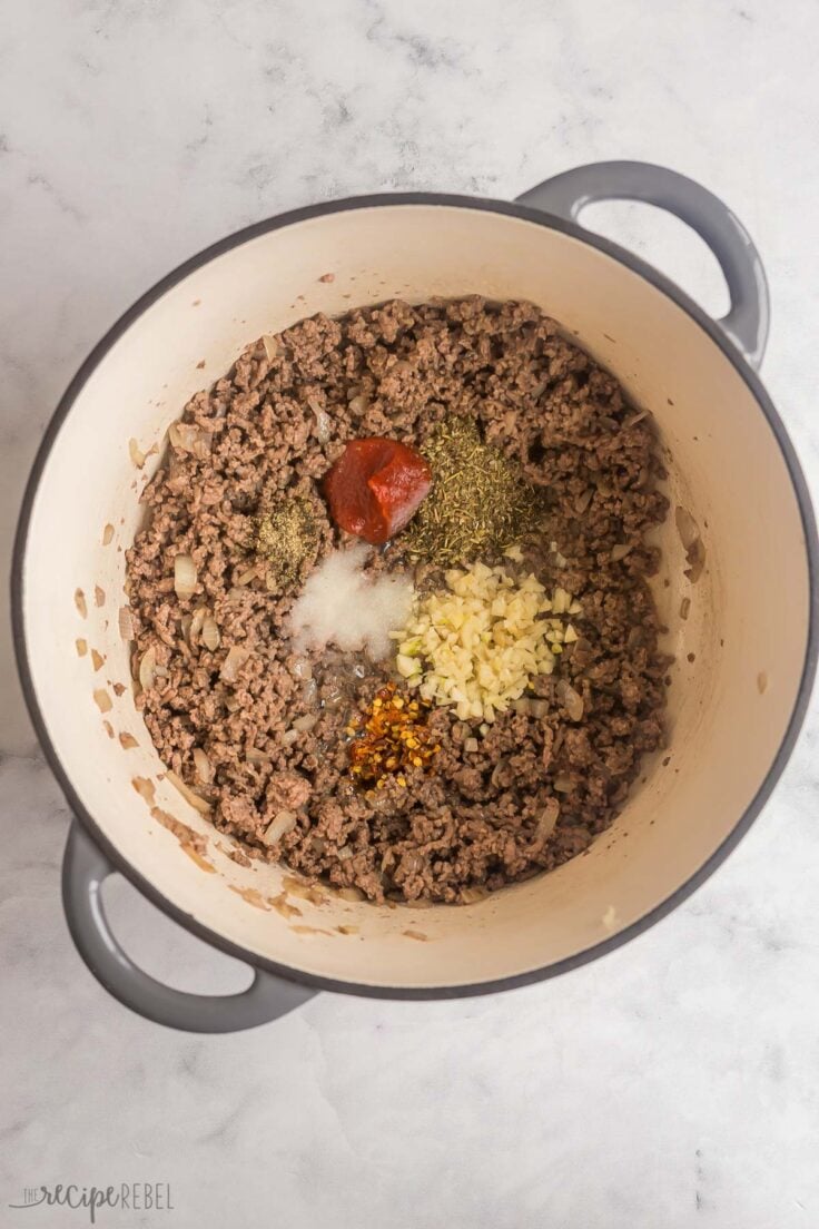 spices and seasonings added to ground beef in large pot