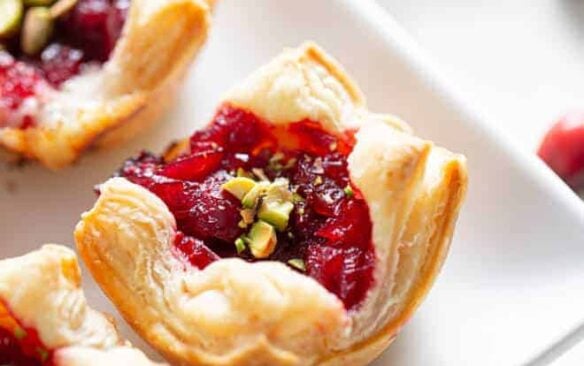 Cranberry brie puff pastry bites on a white plate