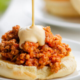 An open-faced turkey Sloppy Joe drizzled with cheese sauce.