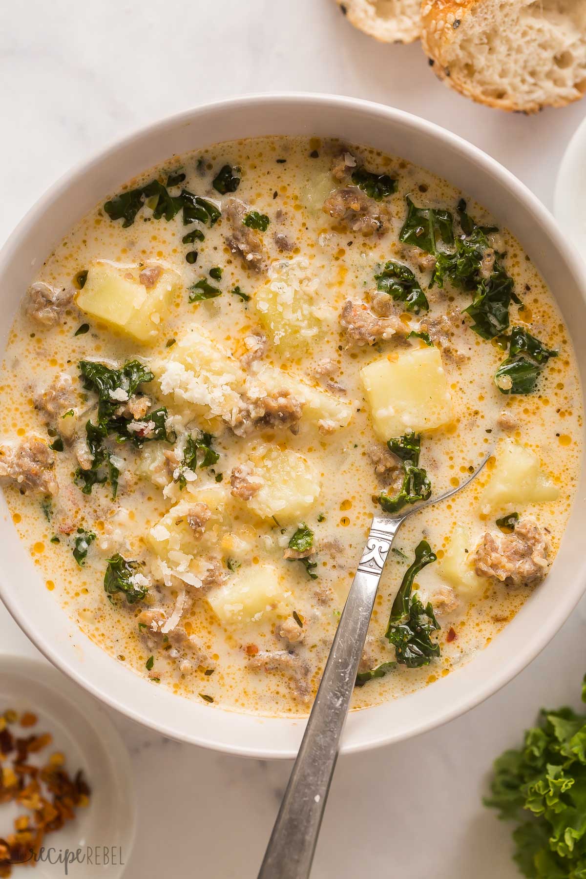 close up image of zuppa toscana in bowl with spoon