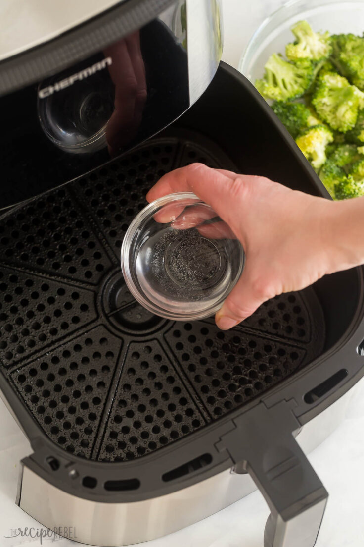 adding water to the bottom of the air fryer to make broccoli